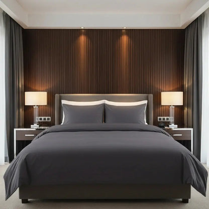 Luxe antraciet dekbedovertrek 240x220 lits-jumeaux van hotelkwaliteit katoen, strak opgemaakt in een moderne slaapkamer met houten wandpanelen, twee nachtkastjes en warme sfeerverlichting.