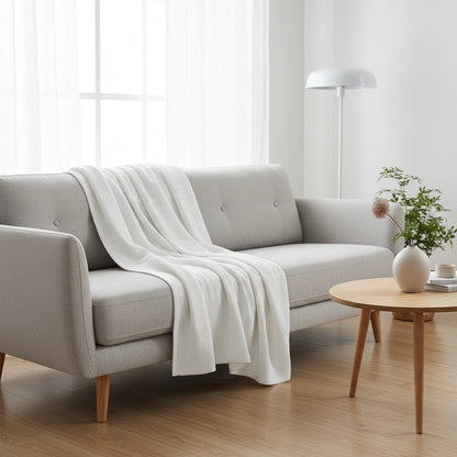 witte plaid van 100% katoen op een grijze bank 