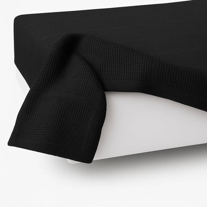 Zijaanzicht van katoenen plaid 130x180 zwart - stijlvolle plaid op bed - Beterkatoen