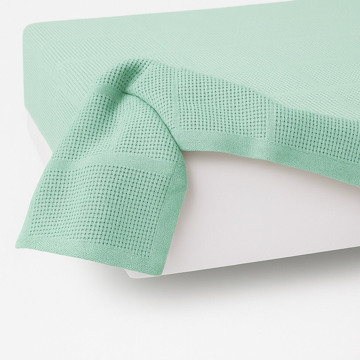 Zijaanzicht van katoenen plaid 150x200 mint groen - stijlvolle plaid op matras bed - Beterkatoen